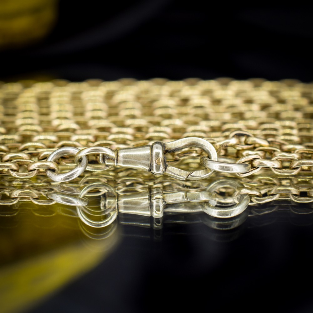 An antique rolled gold long chain with faceted belcher links arranged in loops and secured with a swivel dog clip. View VIII