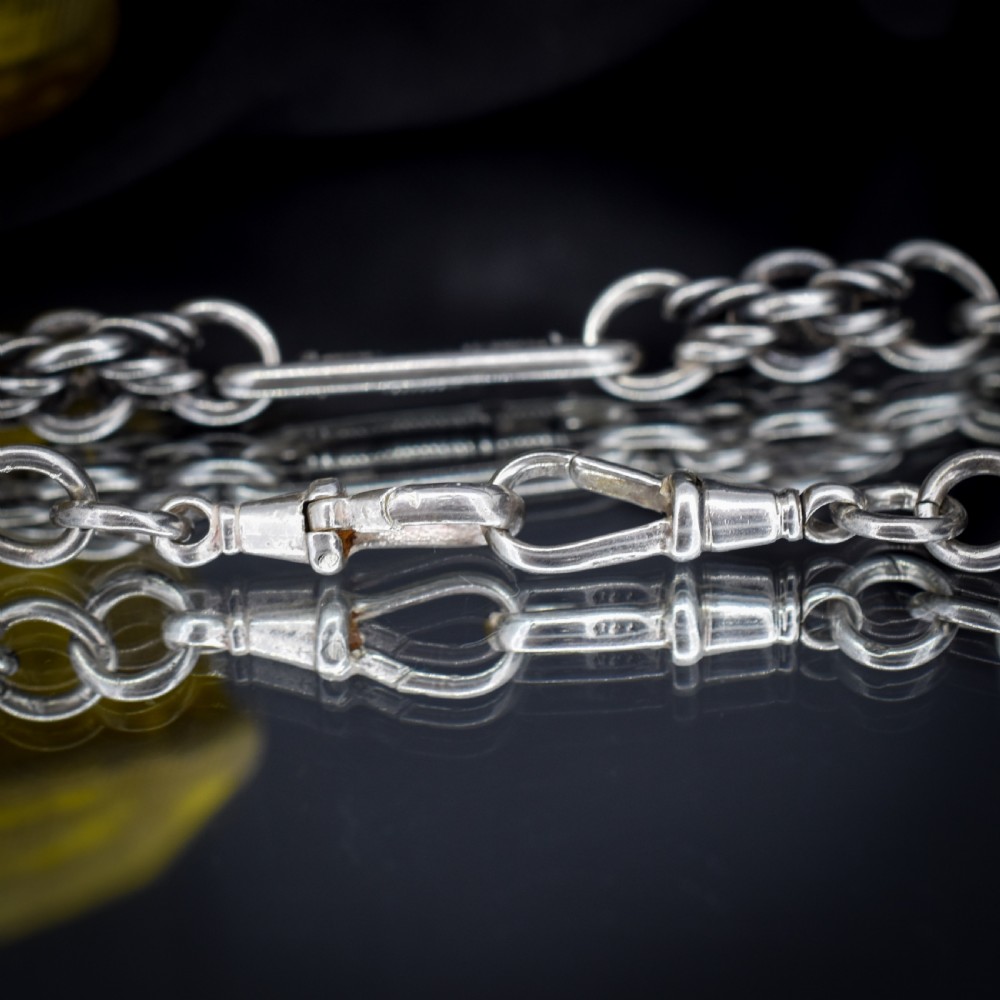 An antique sterling silver Albert chain featuring trombone links, love knot accents, a T-bar fastener, and a swivel dog clip. View VIII