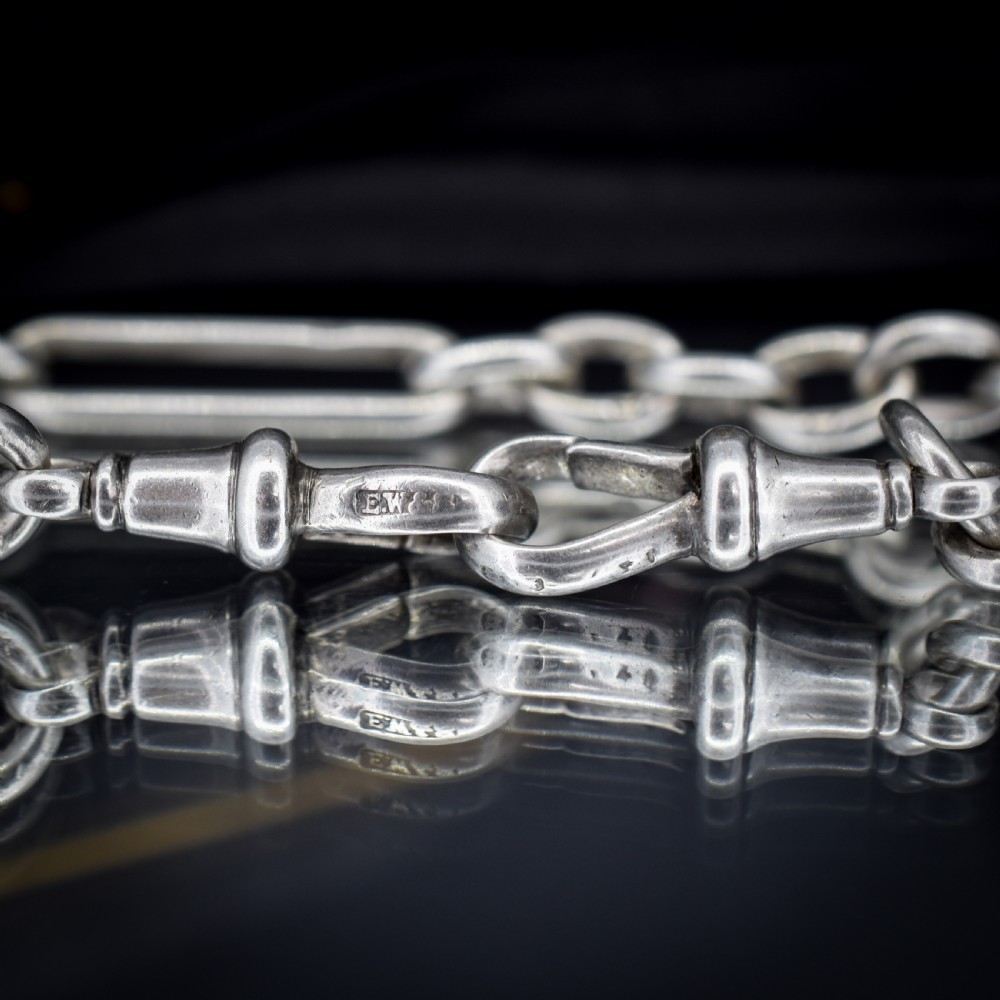 An antique sterling silver Albert chain featuring trombone links, love knot accents, a T-bar fastener, and a swivel dog clip. View XII
