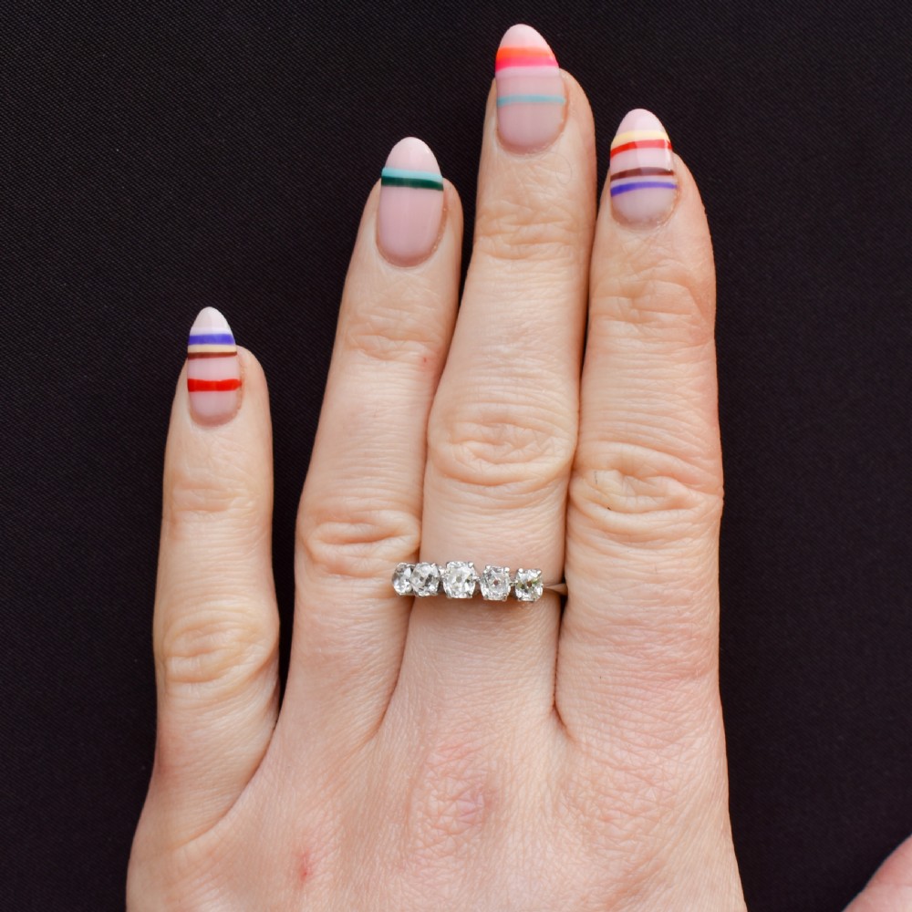 An 18ct white gold five-stone ring set with five graduated old-cut diamonds in claw settings. View II