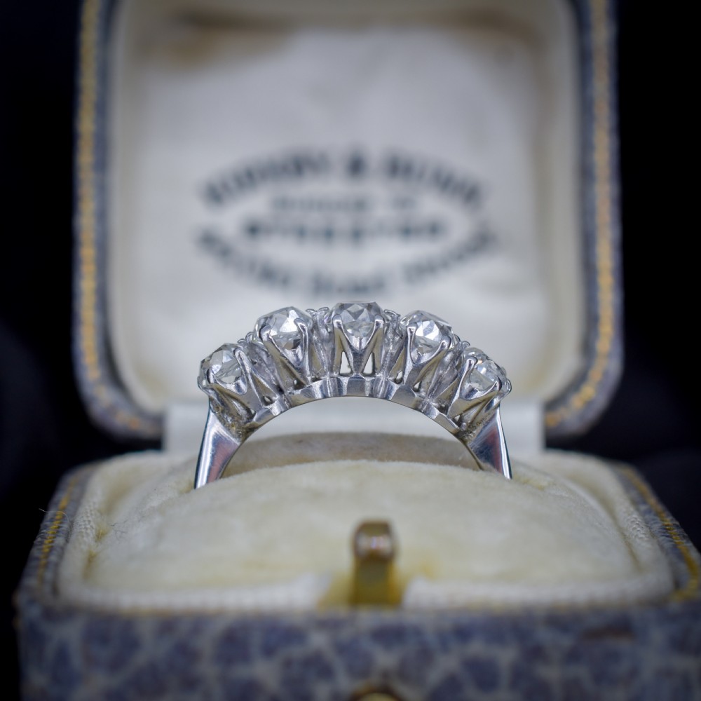 An 18ct white gold five-stone ring set with five graduated old-cut diamonds in claw settings. View IV