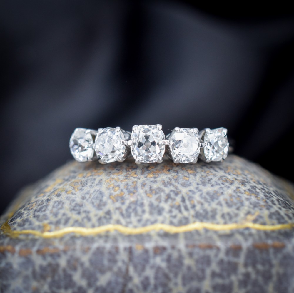 An 18ct white gold five-stone ring set with five graduated old-cut diamonds in claw settings. View V