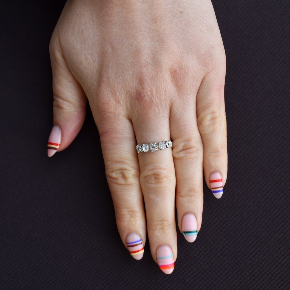 An 18ct white gold five-stone ring set with five graduated old-cut diamonds in claw settings. View VI