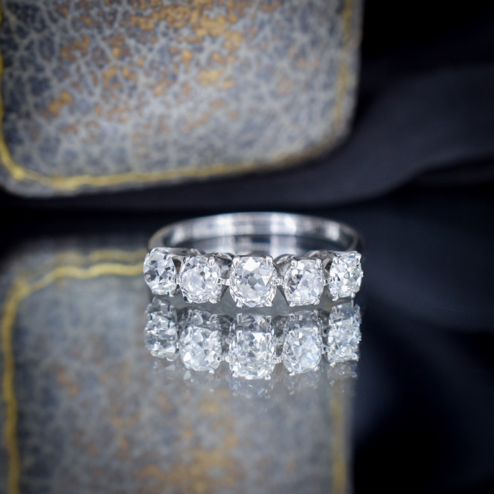 An 18ct white gold five-stone ring set with five graduated old-cut diamonds in claw settings. View VII