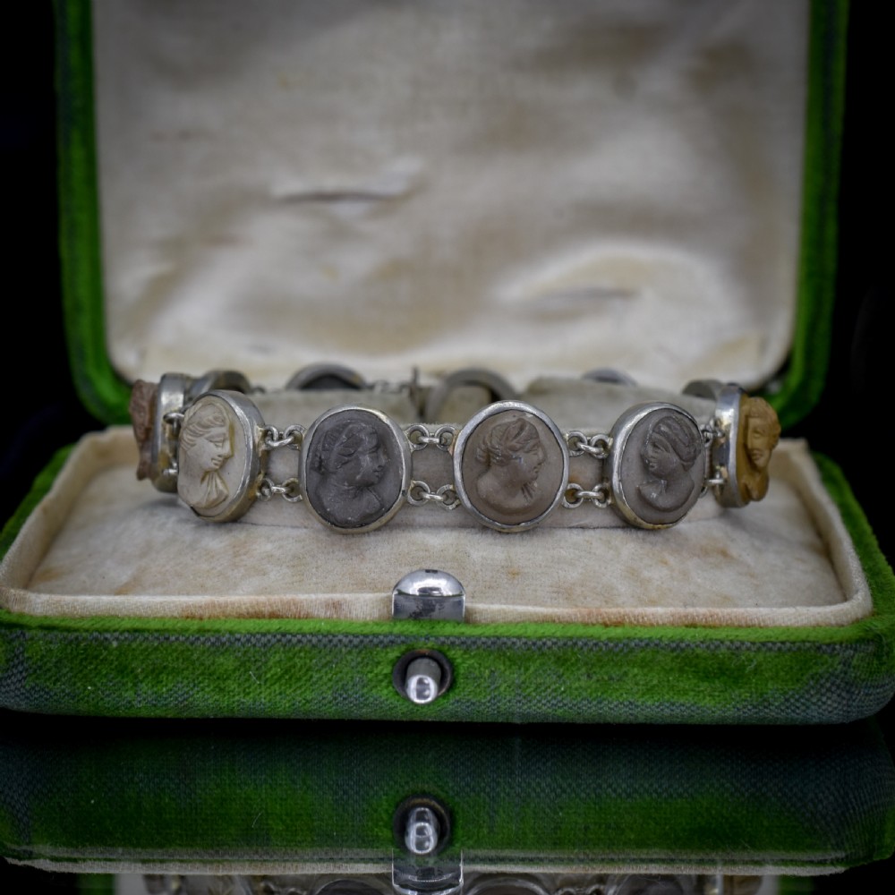 An antique Victorian Grand Tour bracelet featuring oval lava stone cameos carved with classical portrait busts, connected by silver link chains.