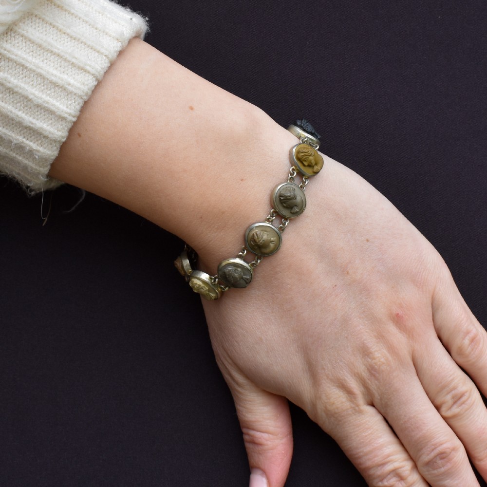 An antique Victorian Grand Tour bracelet featuring oval lava stone cameos carved with classical portrait busts, connected by silver link chains. View III