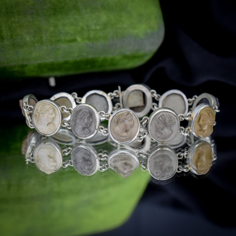 An antique Victorian Grand Tour bracelet featuring oval lava stone cameos carved with classical portrait busts, connected by silver link chains. View VIII