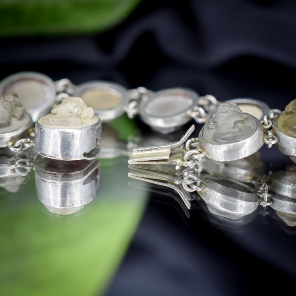 An antique Victorian Grand Tour bracelet featuring oval lava stone cameos carved with classical portrait busts, connected by silver link chains. View IX
