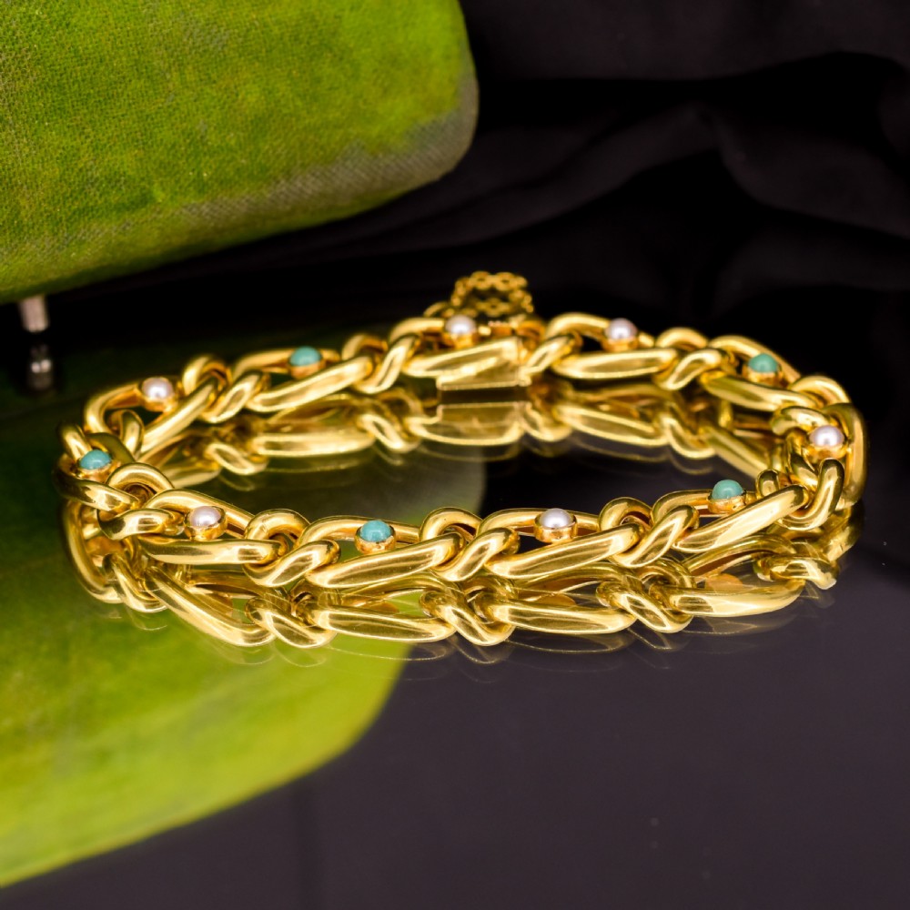 An antique 15ct yellow gold curb link bracelet featuring inset seed pearls and round turquoise cabochons with an attached safety chain. View IX