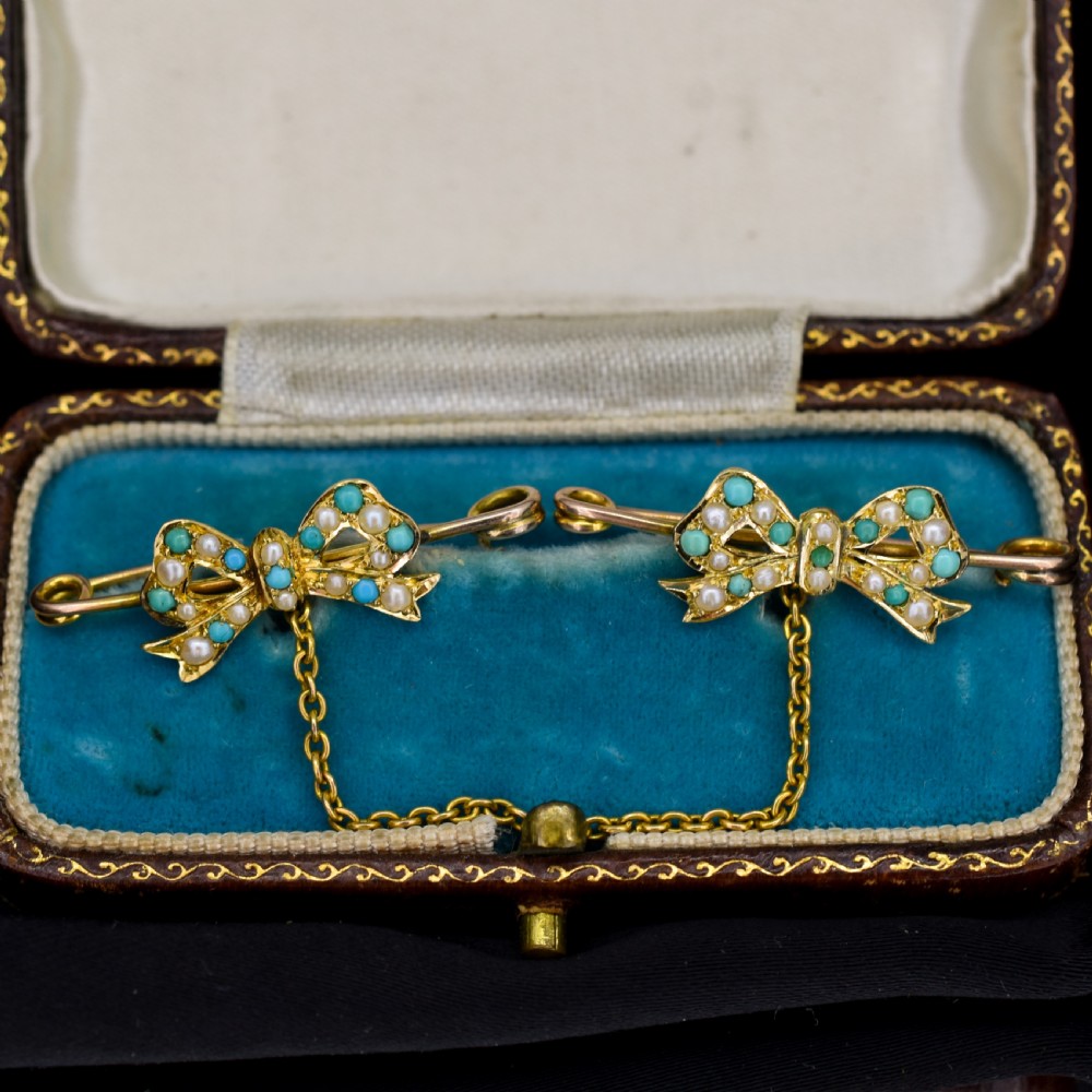 A pair of 15ct gold bow-shaped collar brooches set with seed pearls and turquoise cabochons, linked together by a delicate gold trace chain. View II