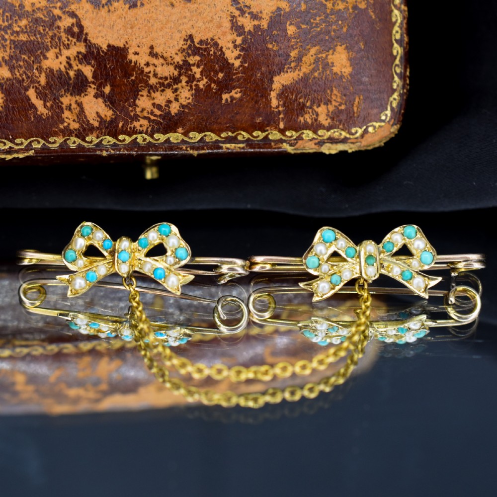 A pair of 15ct gold bow-shaped collar brooches set with seed pearls and turquoise cabochons, linked together by a delicate gold trace chain. View VI