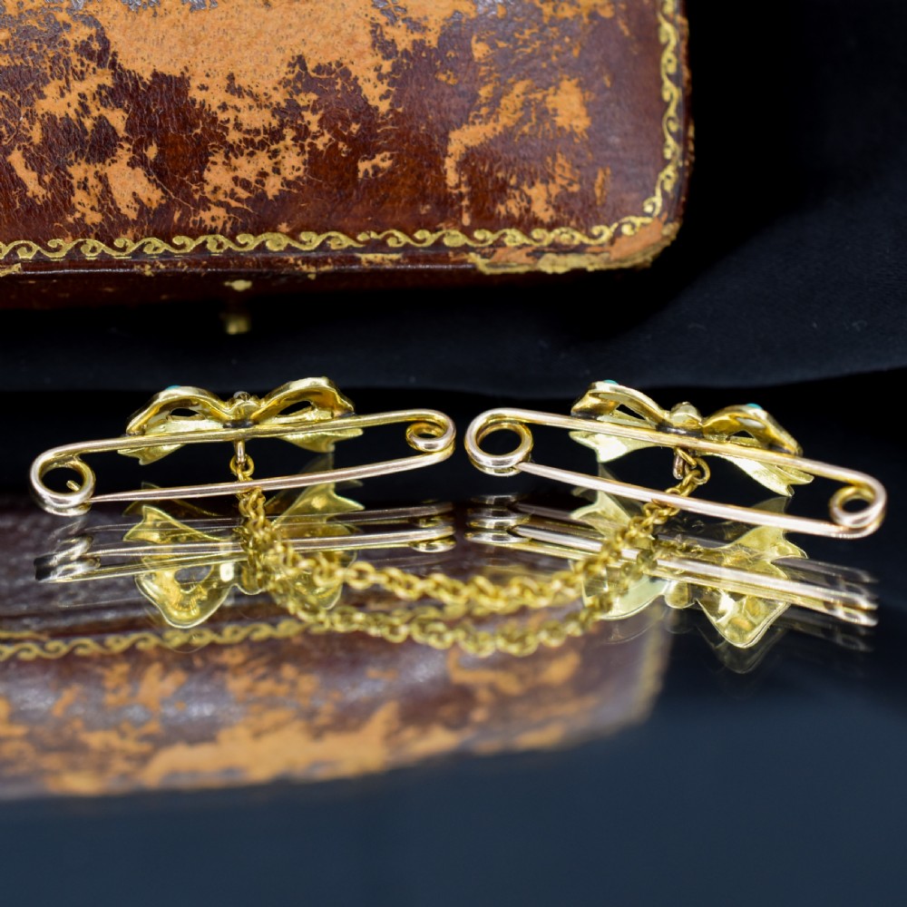 A pair of 15ct gold bow-shaped collar brooches set with seed pearls and turquoise cabochons, linked together by a delicate gold trace chain. View VIII
