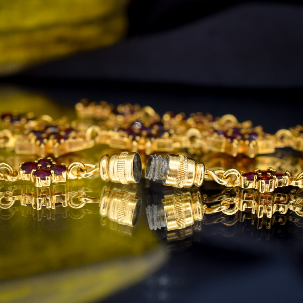 A Victorian gold gilt necklace set with deep red rose-cut Bohemian garnets featuring starburst clusters and drop pendants. View XII