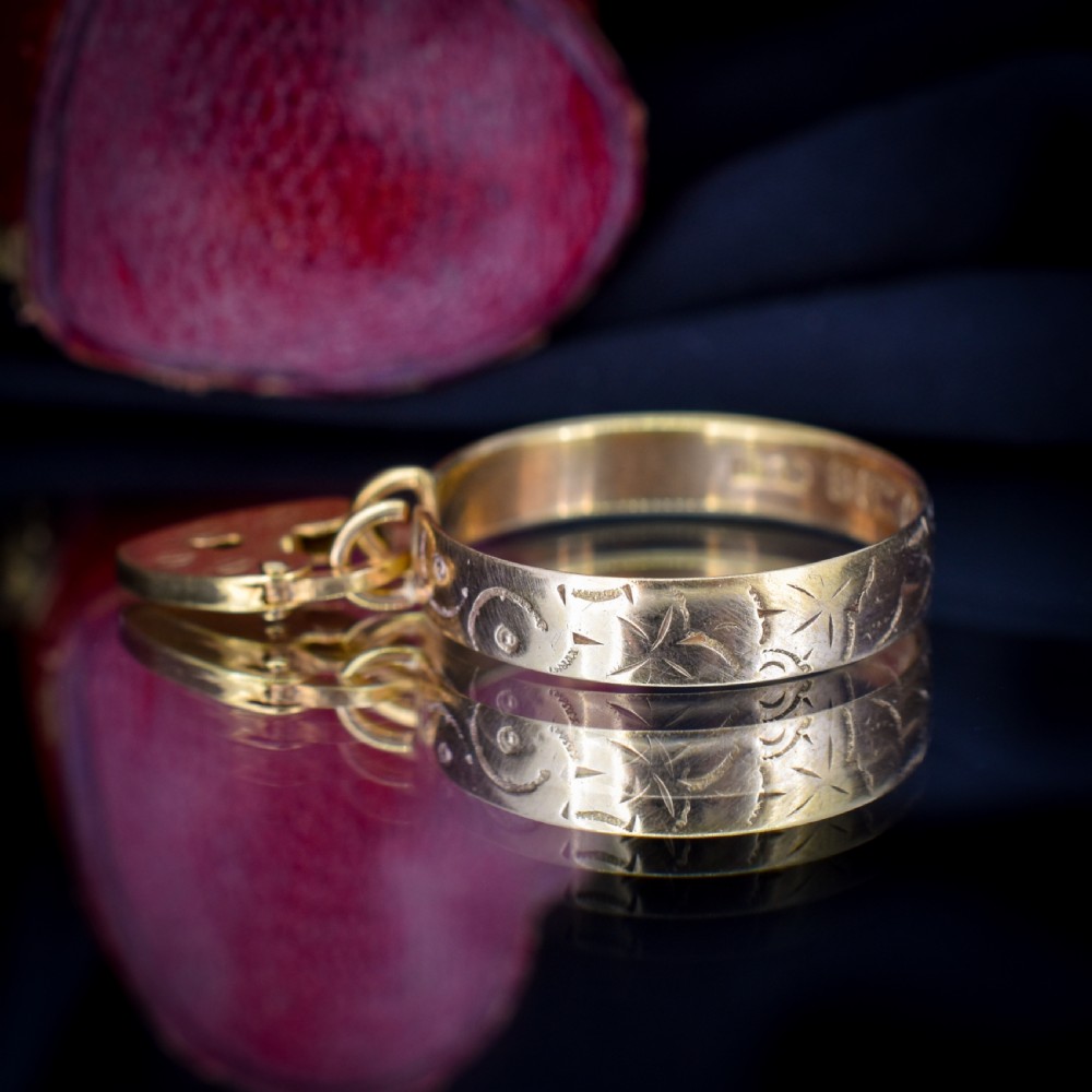 An engraved 9ct yellow gold band featuring a dangling heart padlock charm. View VIII