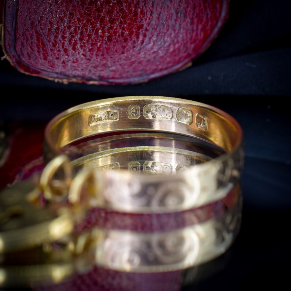 An engraved 9ct yellow gold band featuring a dangling heart padlock charm. View IX