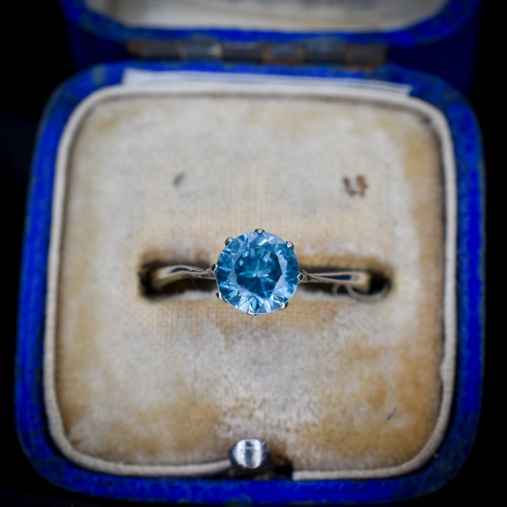 A vintage 9ct gold solitaire ring featuring a brilliant round-cut blue zircon gemstone held in a multi-claw setting.