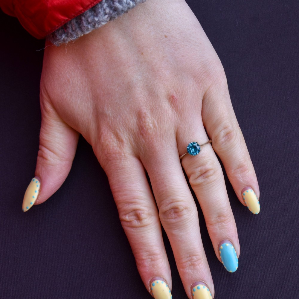 A vintage 9ct gold solitaire ring featuring a brilliant round-cut blue zircon gemstone held in a multi-claw setting. View III