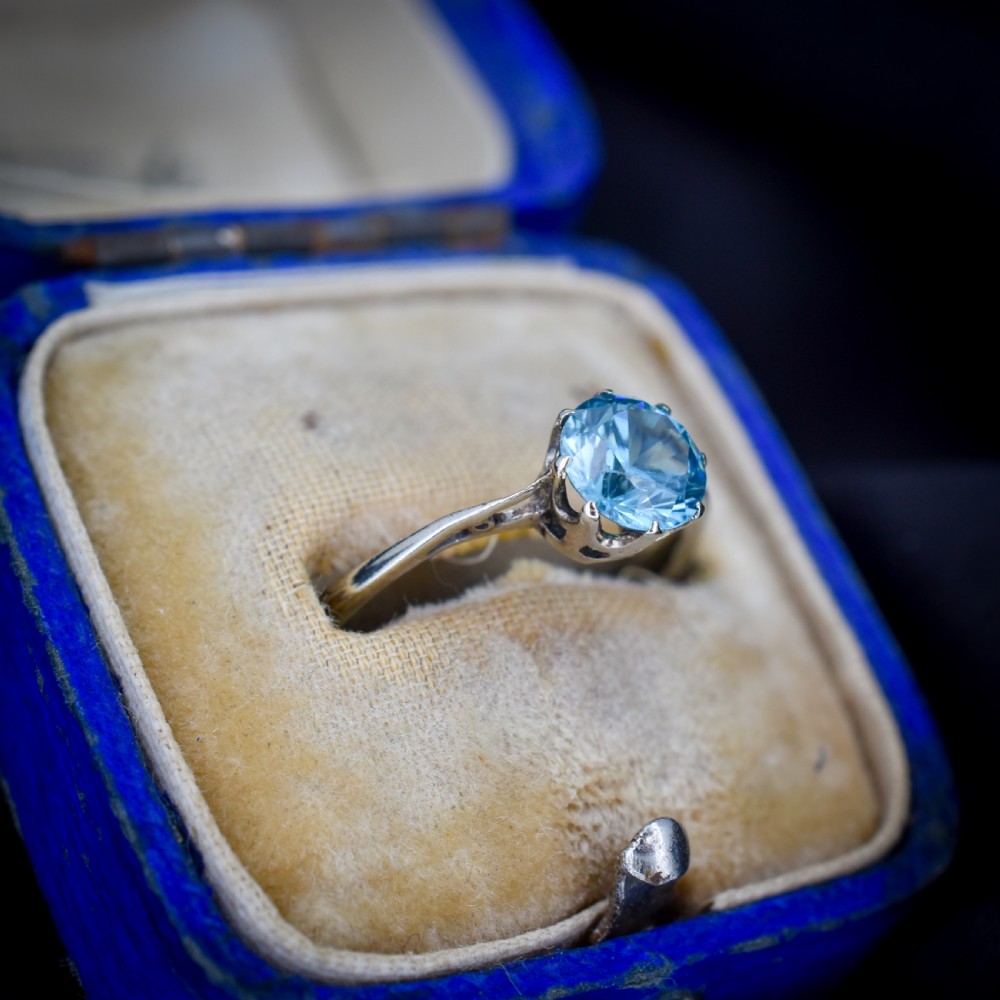A vintage 9ct gold solitaire ring featuring a brilliant round-cut blue zircon gemstone held in a multi-claw setting. View IV