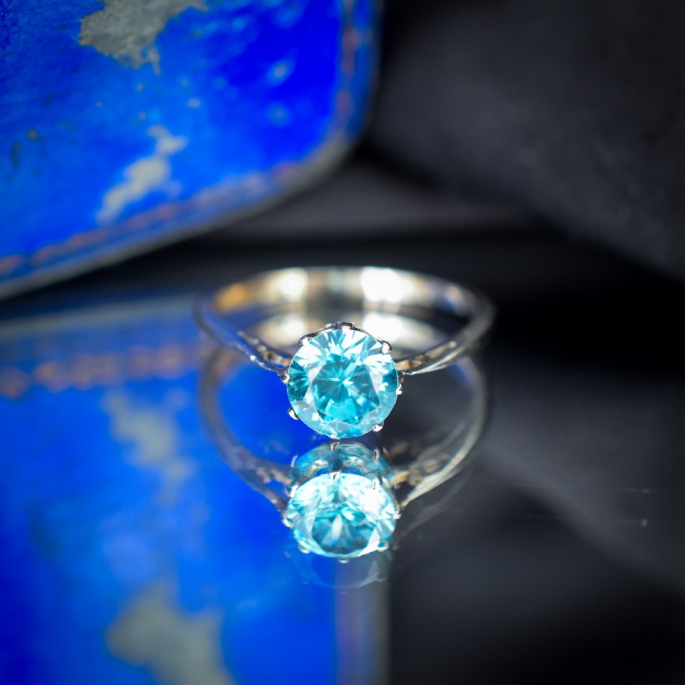 A vintage 9ct gold solitaire ring featuring a brilliant round-cut blue zircon gemstone held in a multi-claw setting. View V