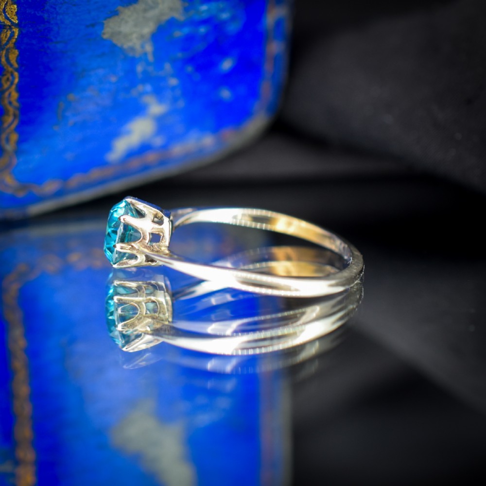 A vintage 9ct gold solitaire ring featuring a brilliant round-cut blue zircon gemstone held in a multi-claw setting. View VII