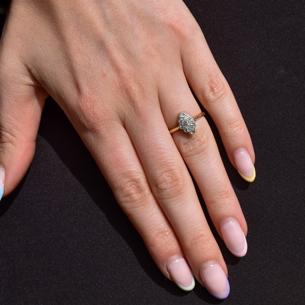 An Art Deco navette cluster ring featuring old-cut diamonds mounted in platinum on an 18ct yellow gold band. View X
