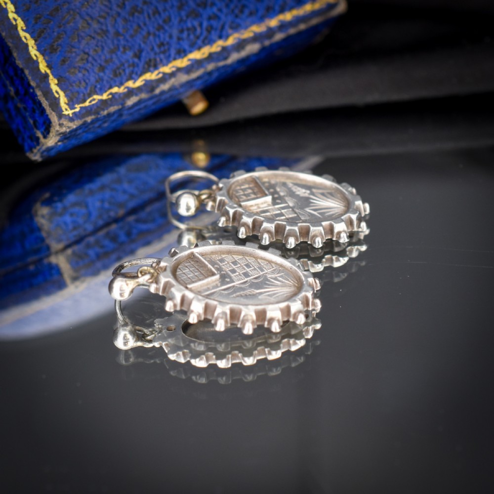 A pair of oval sterling silver Victorian Aesthetic Movement drop earrings featuring engraved geometric and botanical designs with beaded borders. View VIII
