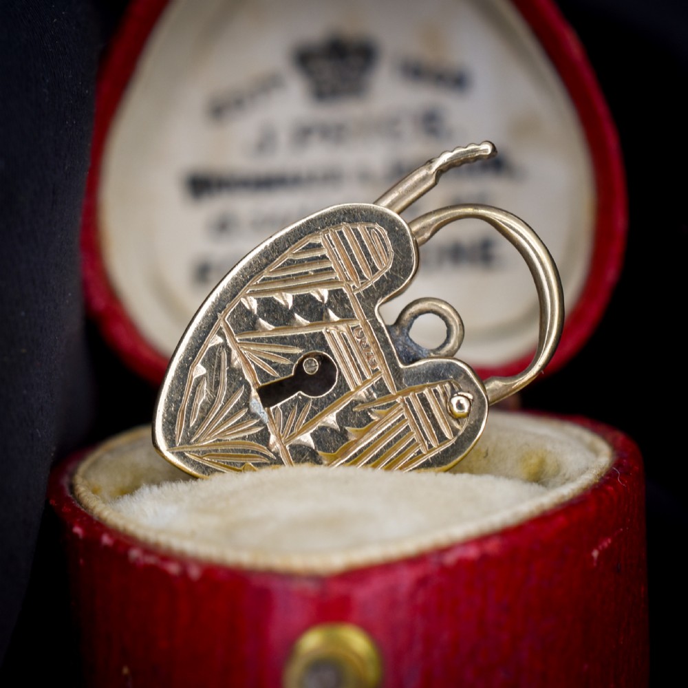 A vintage 9ct yellow gold heart-shaped padlock charm with geometric and botanical hand-engraved patterns and a keyhole detail. View V