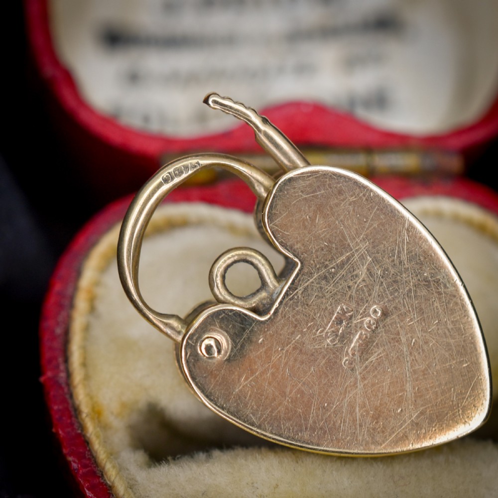 A vintage 9ct yellow gold heart-shaped padlock charm with geometric and botanical hand-engraved patterns and a keyhole detail. View VII