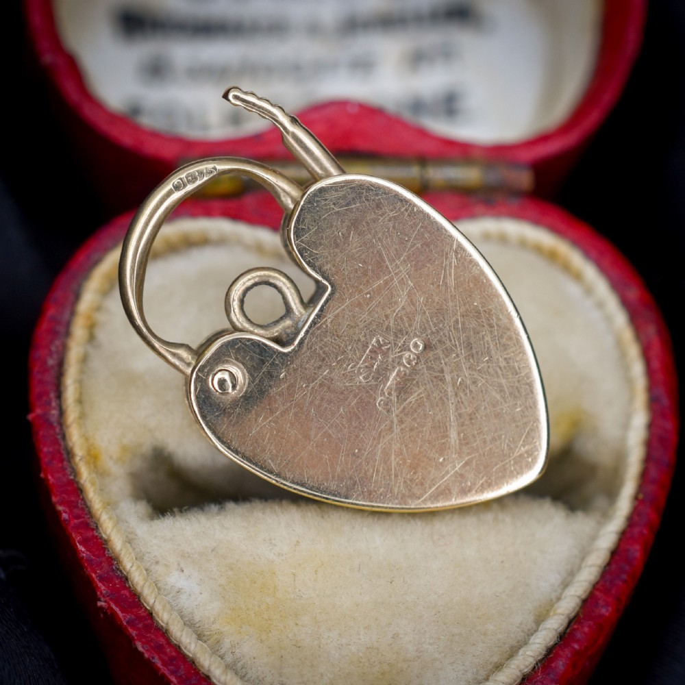 A vintage 9ct yellow gold heart-shaped padlock charm with geometric and botanical hand-engraved patterns and a keyhole detail. View VIII