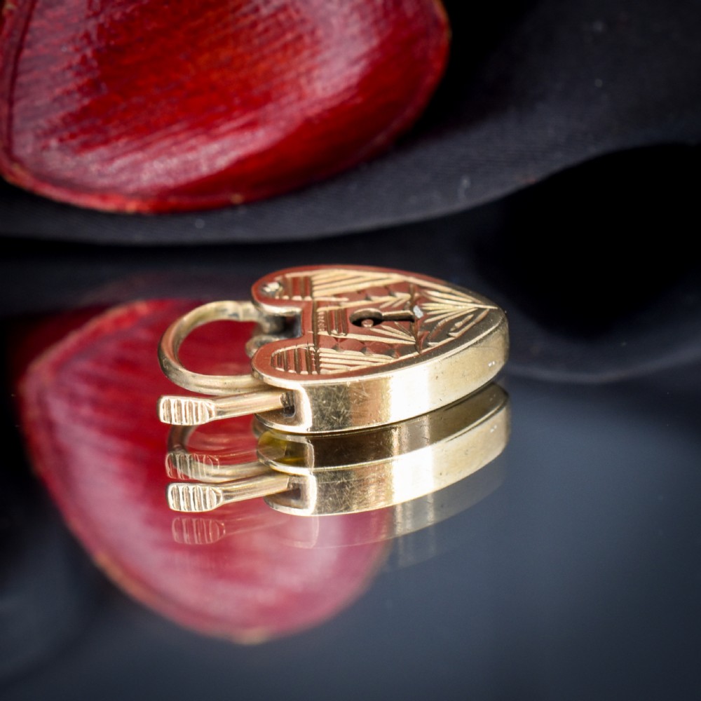 A vintage 9ct yellow gold heart-shaped padlock charm with geometric and botanical hand-engraved patterns and a keyhole detail. View IX