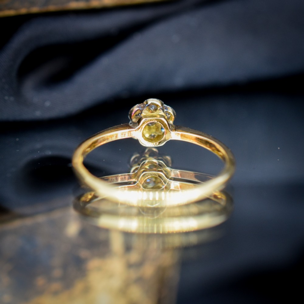 An 18ct yellow gold ring featuring a floral diamond cluster head set in white metal. View VI