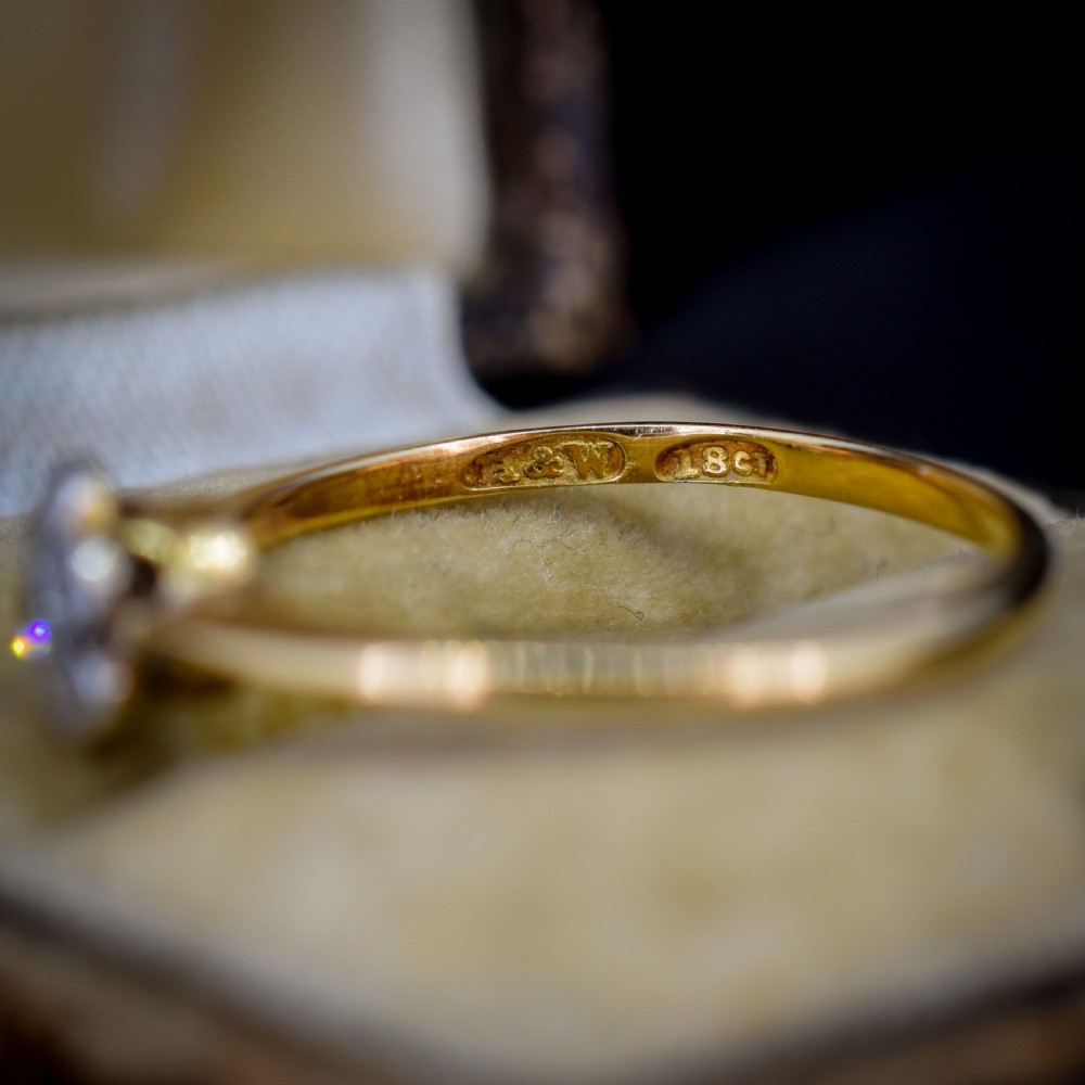 An 18ct yellow gold ring featuring a floral diamond cluster head set in white metal. View VII