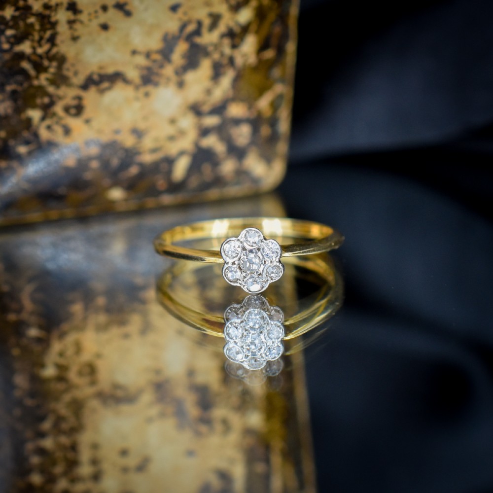 An 18ct yellow gold ring featuring a floral diamond cluster head set in white metal. View VIII