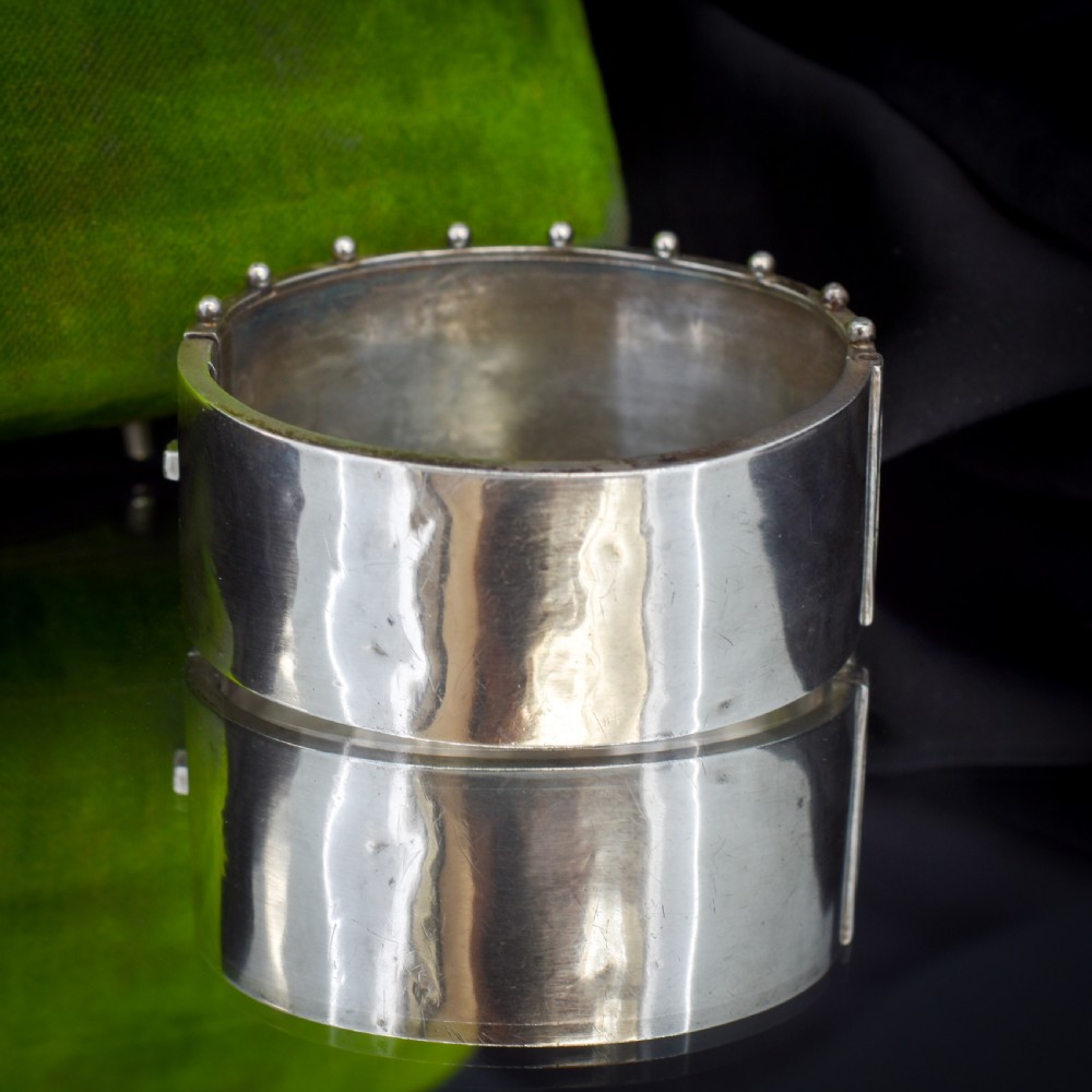 A wide Victorian silver hinged cuff bangle featuring hand-engraved bamboo stalks and foliage, applied gold birds, and beaded studded borders along the top and bottom rims. View III