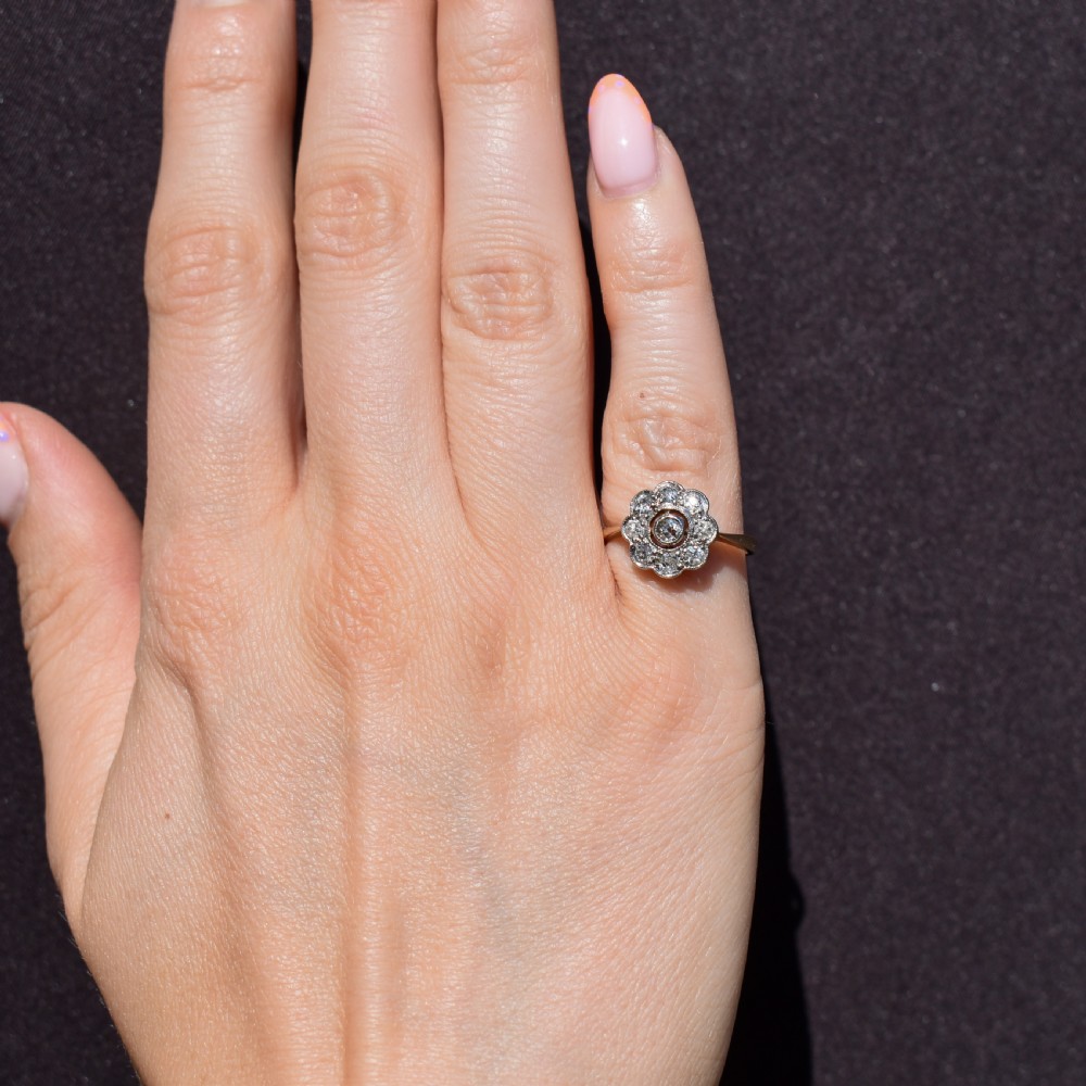 An antique diamond cluster ring in a flower shape set in platinum with an 18ct yellow gold band. View IV