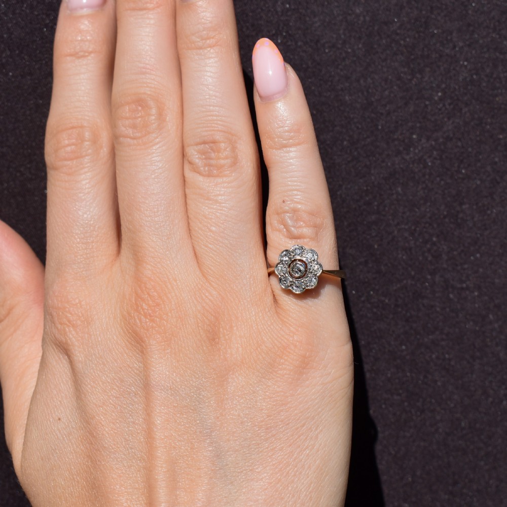 An antique diamond cluster ring in a flower shape set in platinum with an 18ct yellow gold band. View V