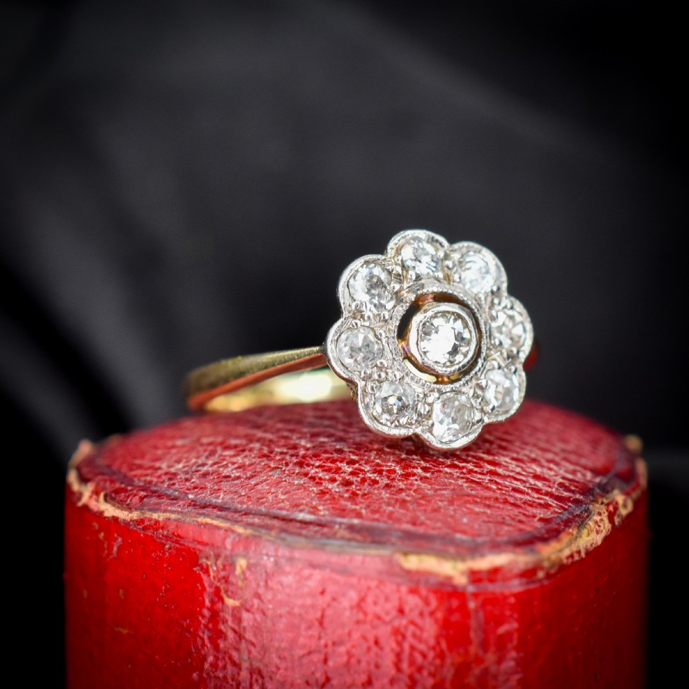 An antique diamond cluster ring in a flower shape set in platinum with an 18ct yellow gold band. View VI