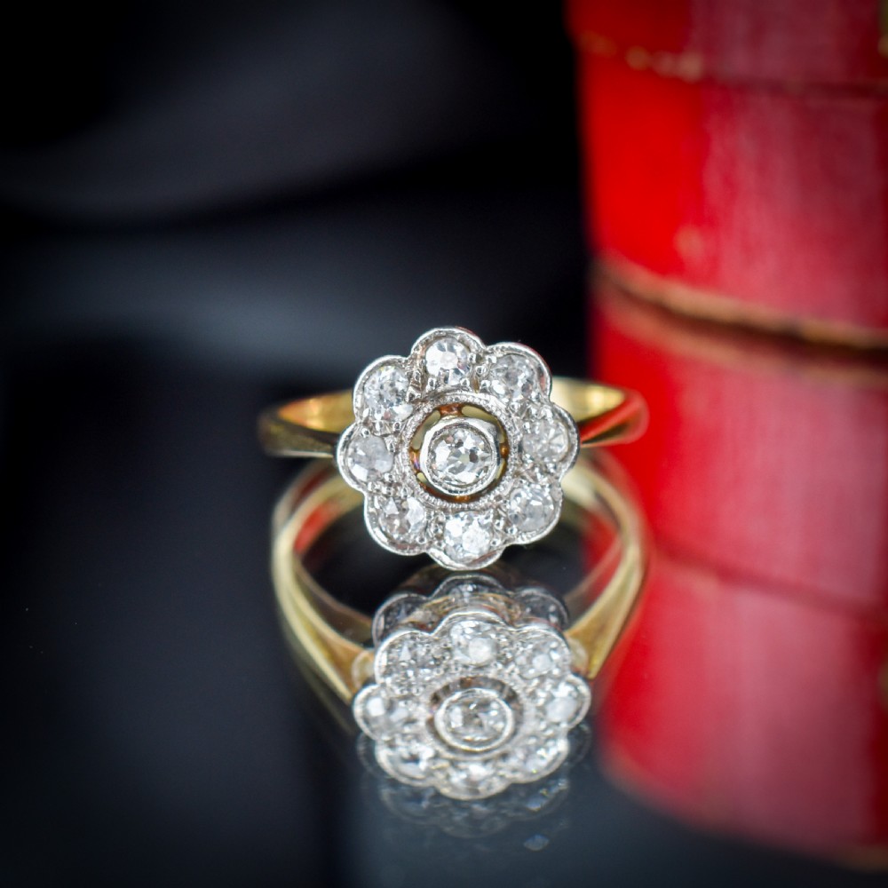 An antique diamond cluster ring in a flower shape set in platinum with an 18ct yellow gold band. View VII