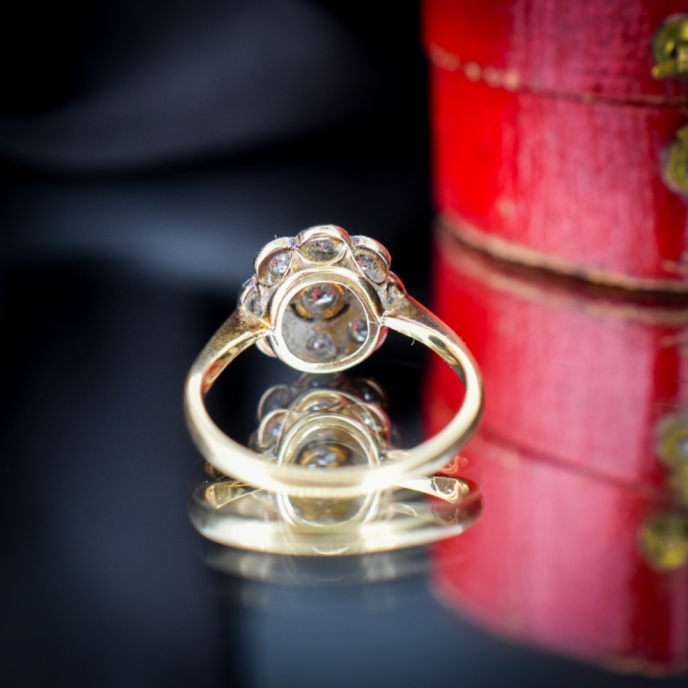 An antique diamond cluster ring in a flower shape set in platinum with an 18ct yellow gold band. View IX