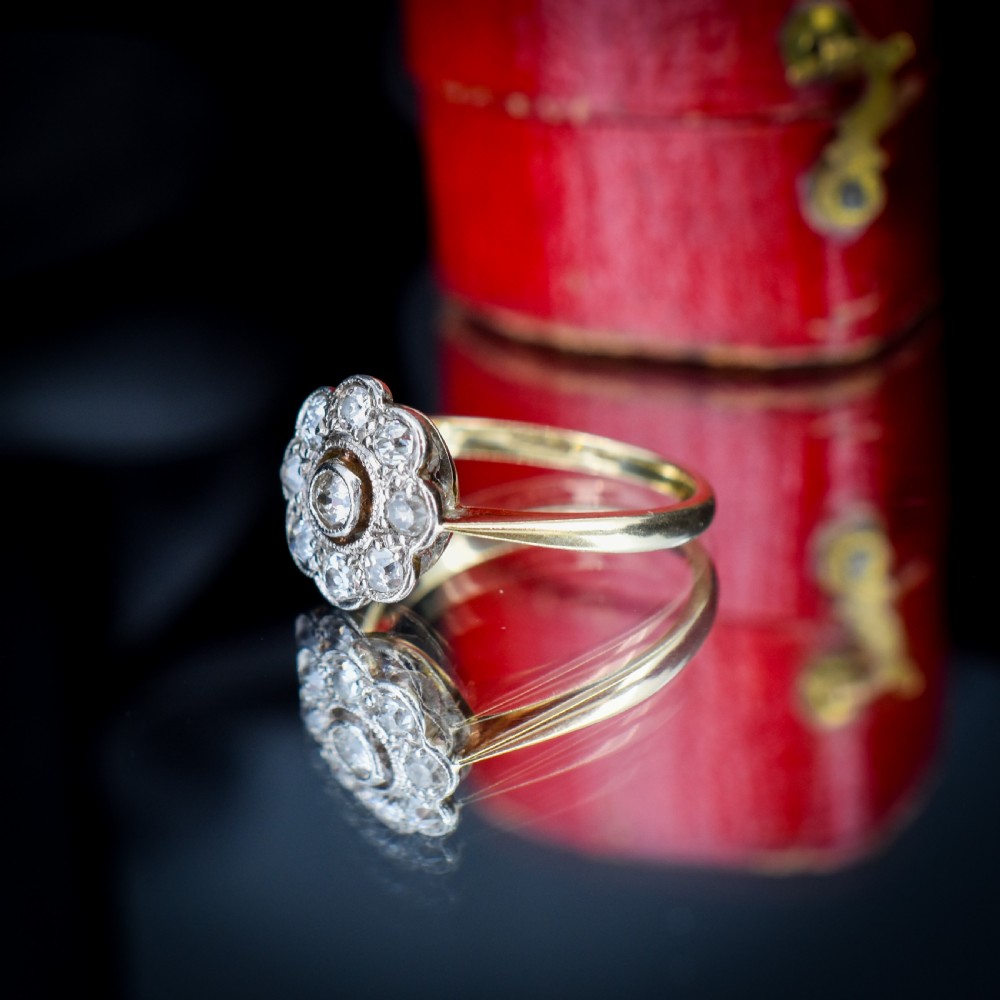 An antique diamond cluster ring in a flower shape set in platinum with an 18ct yellow gold band. View X