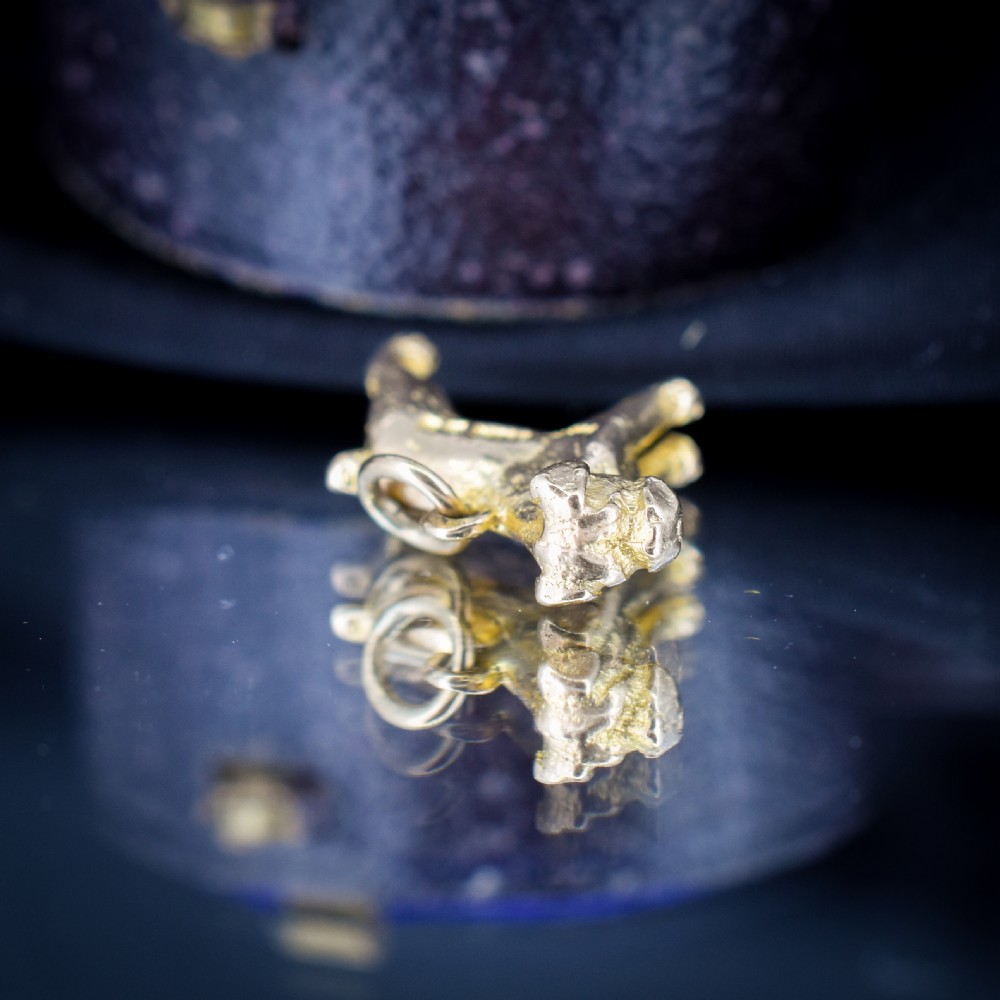 A solid 9ct yellow gold charm shaped as a standing boxer dog with visible hallmarks stamped on its side. View V