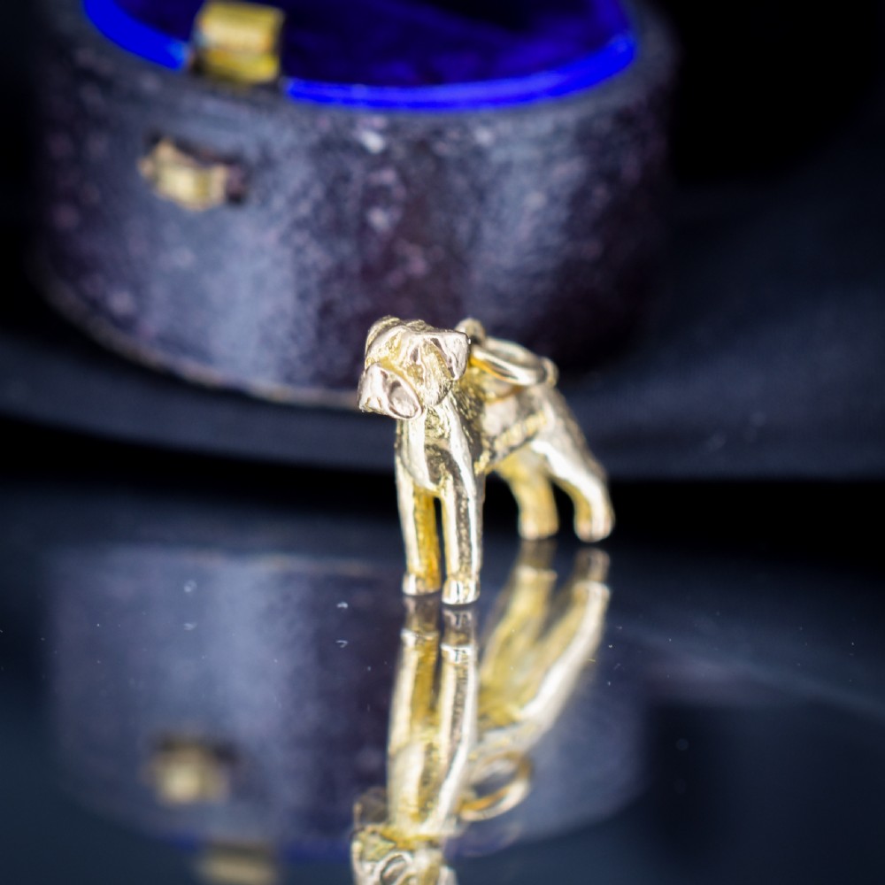 A solid 9ct yellow gold charm shaped as a standing boxer dog with visible hallmarks stamped on its side. View VII