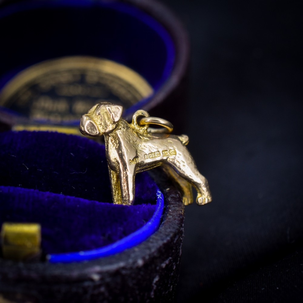 A solid 9ct yellow gold charm shaped as a standing boxer dog with visible hallmarks stamped on its side. View VIII