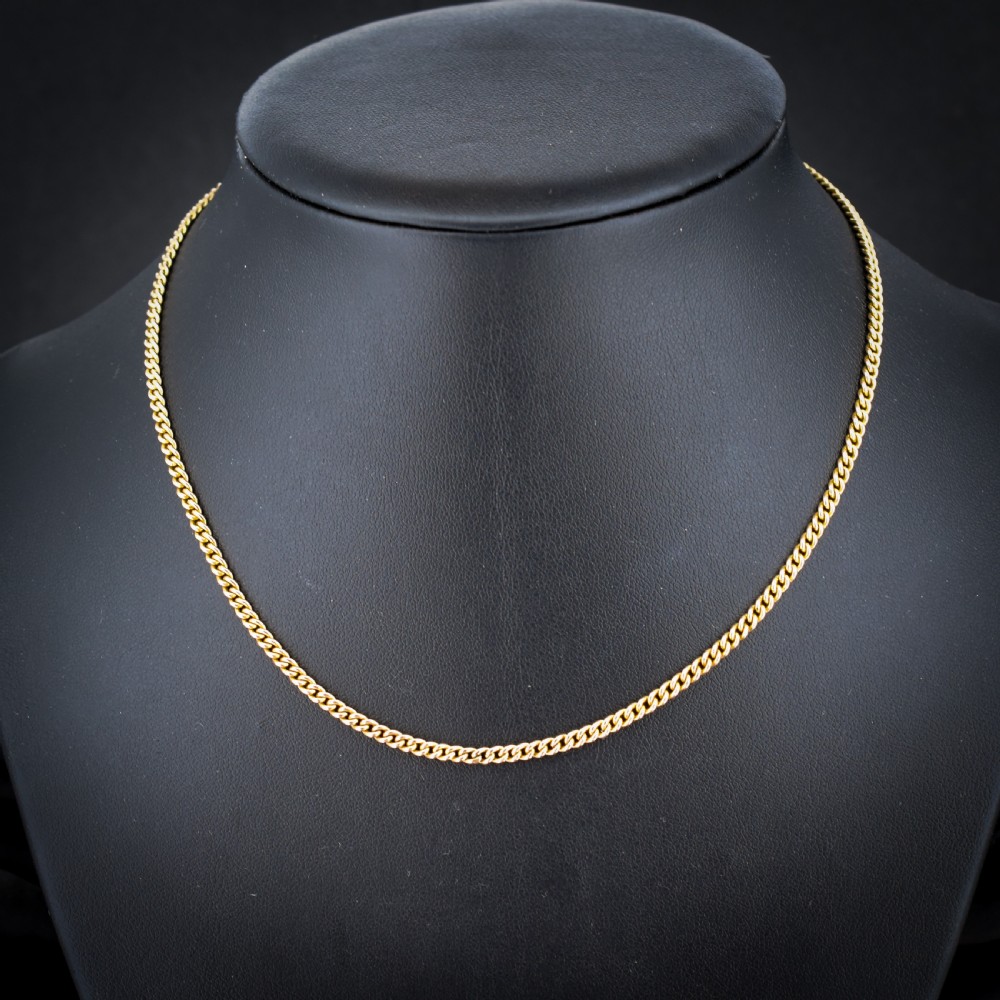 An antique 9ct yellow gold flat curb link chain necklace featuring a cylindrical barrel clasp. View II