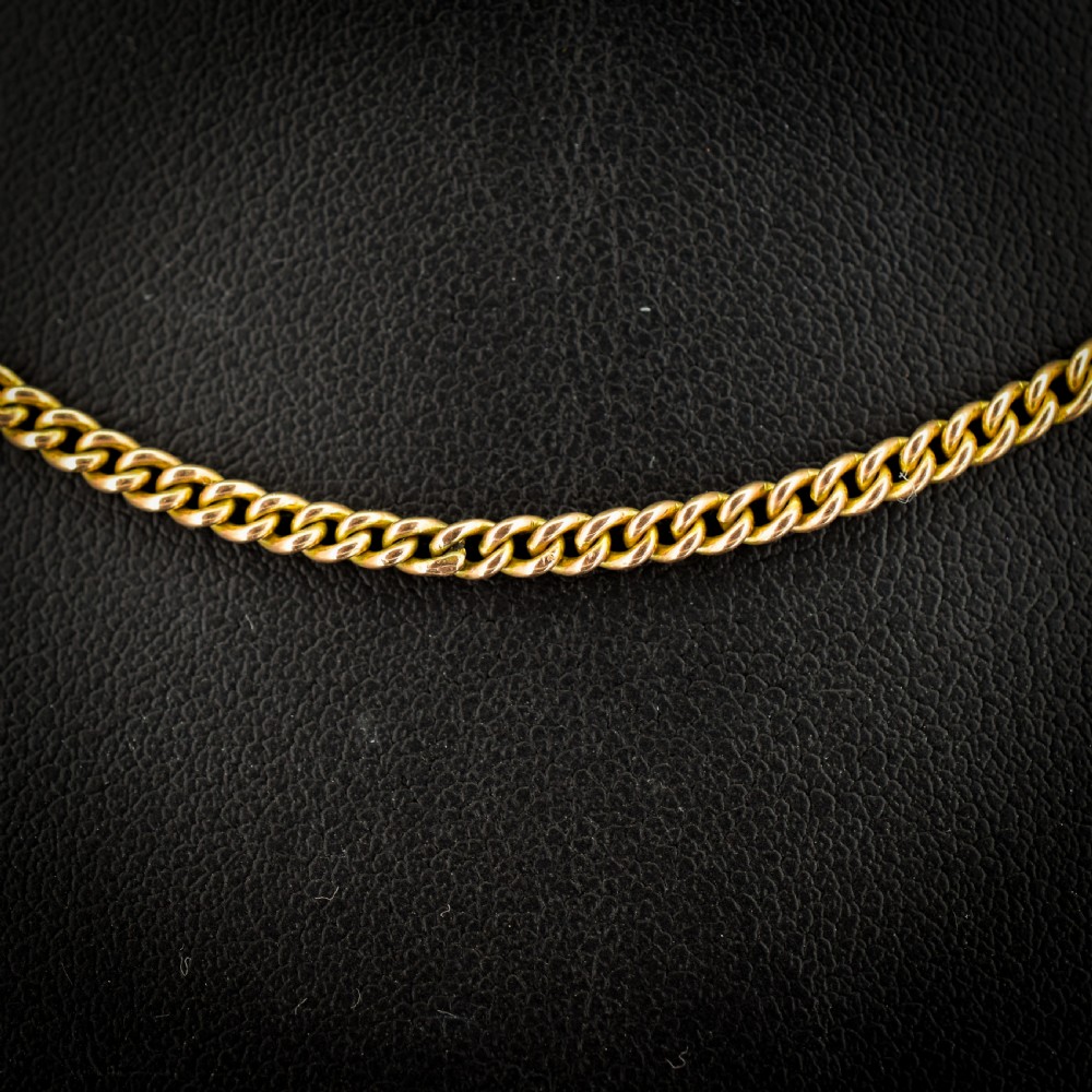 An antique 9ct yellow gold flat curb link chain necklace featuring a cylindrical barrel clasp. View III