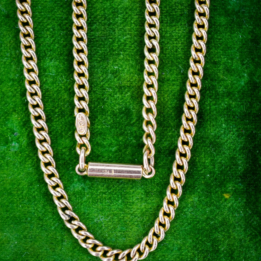 An antique 9ct yellow gold flat curb link chain necklace featuring a cylindrical barrel clasp. View IV