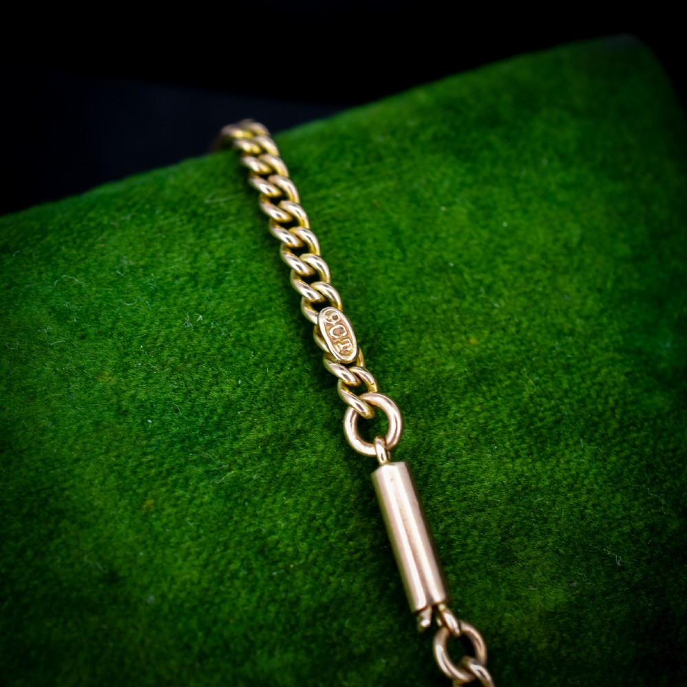 An antique 9ct yellow gold flat curb link chain necklace featuring a cylindrical barrel clasp. View VII
