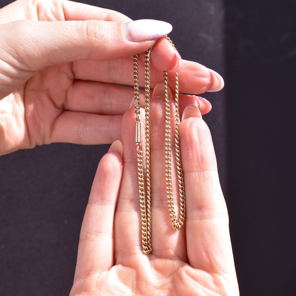 An antique 9ct yellow gold flat curb link chain necklace featuring a cylindrical barrel clasp. View IX