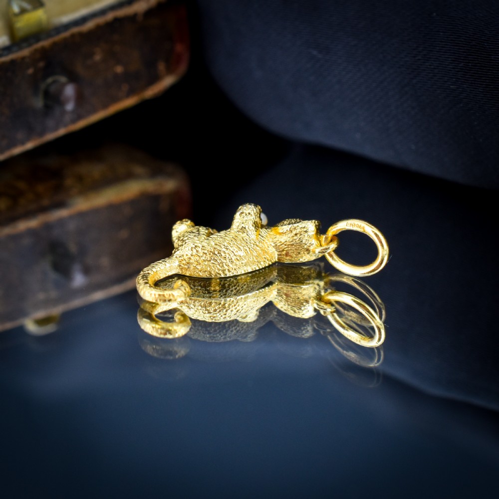A 9ct yellow gold cat charm in a seated pose with textured fur detail holding a small cultured pearl in its paws. View III