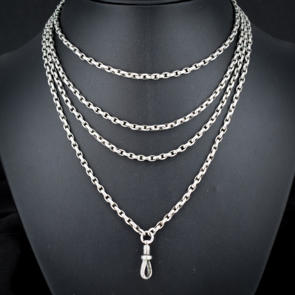 An antique silver long guard chain featuring multiple loops of belcher links terminating in a swivel dog clip clasp. View II